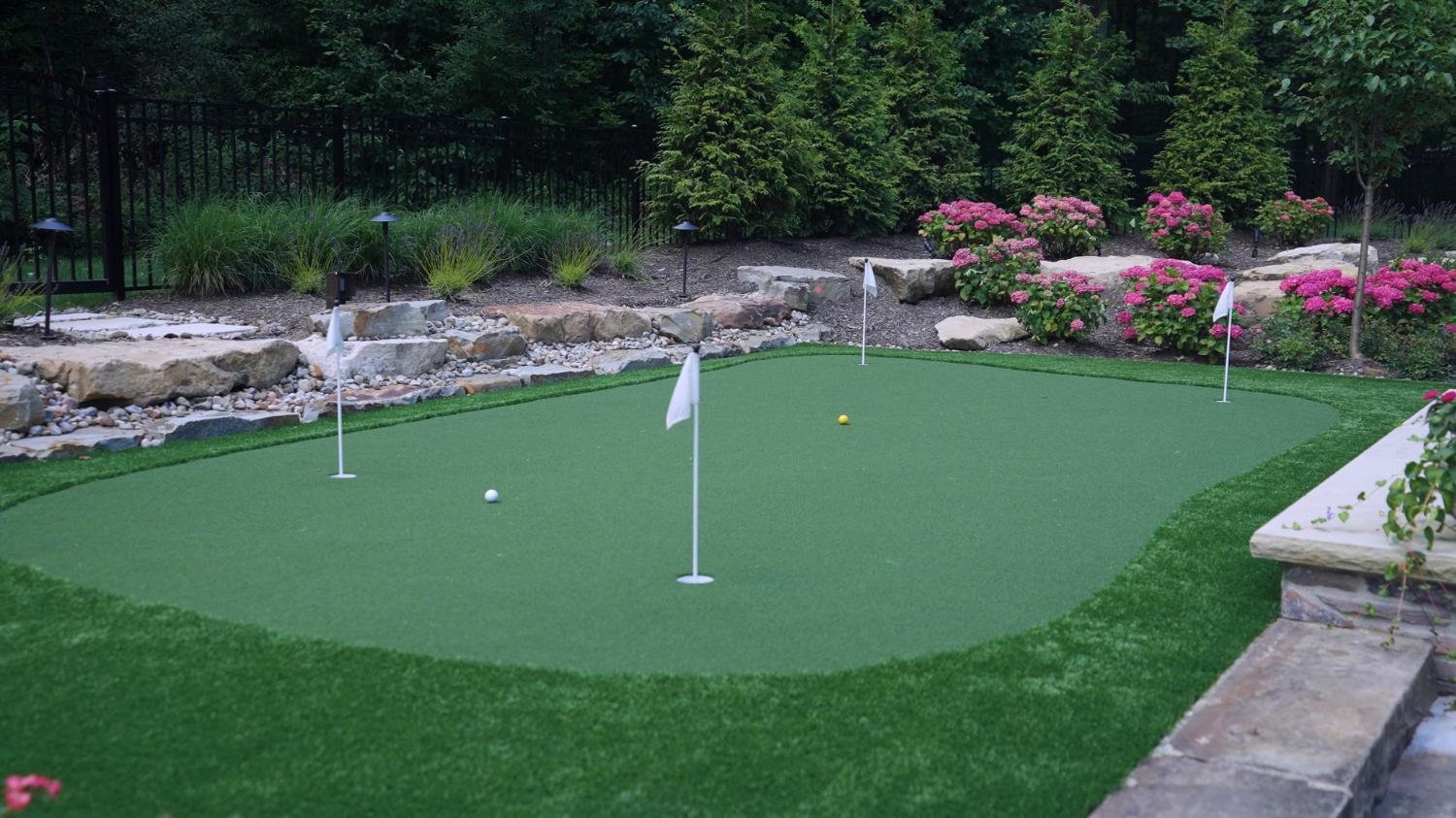 Backyard retreat featuring stone, turf, and masonry in Northeast Ohio
