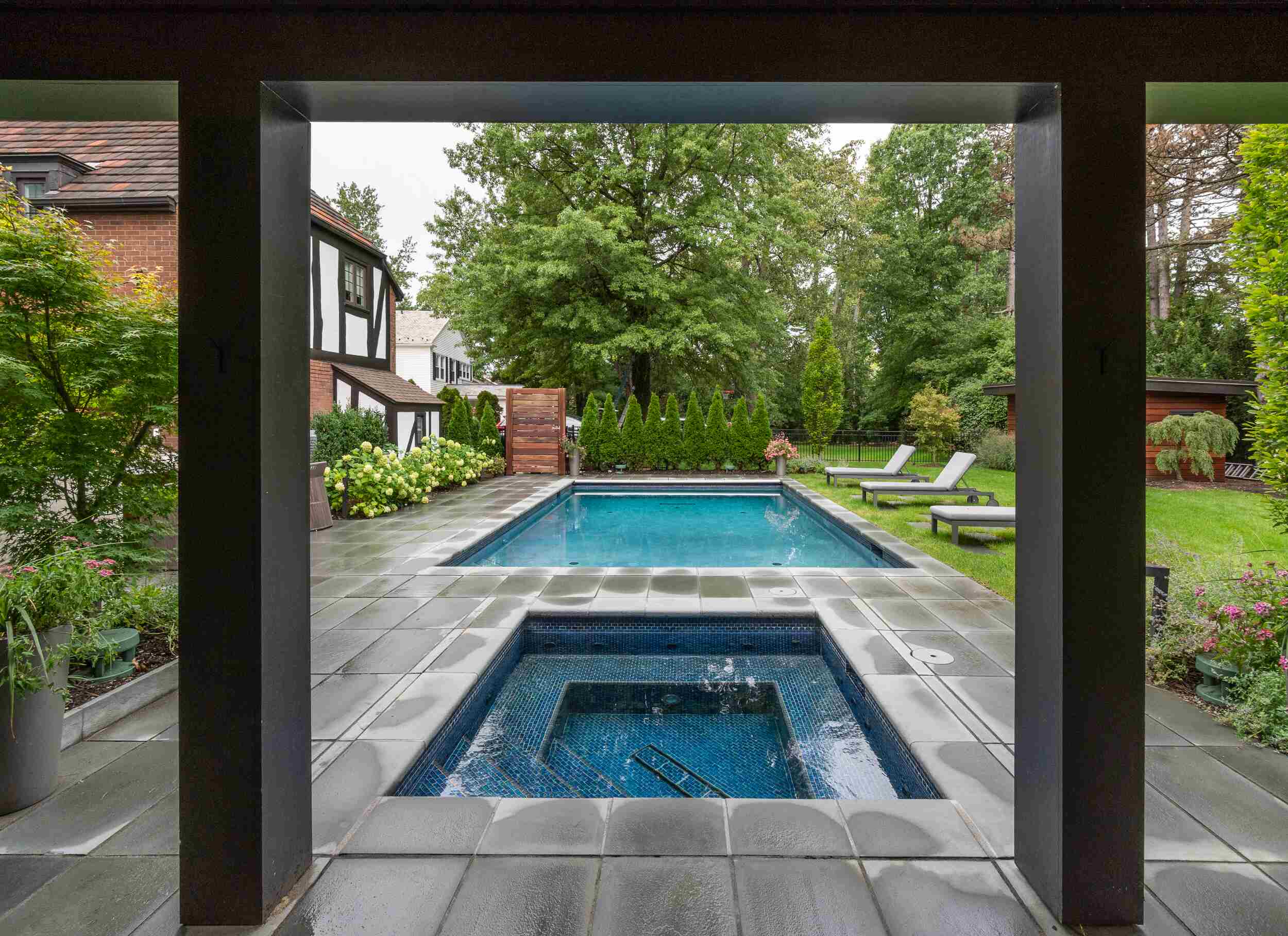 Elegant rectangular swimming pool with a stone deck in a stylish backyard retreat in Novelty, OH