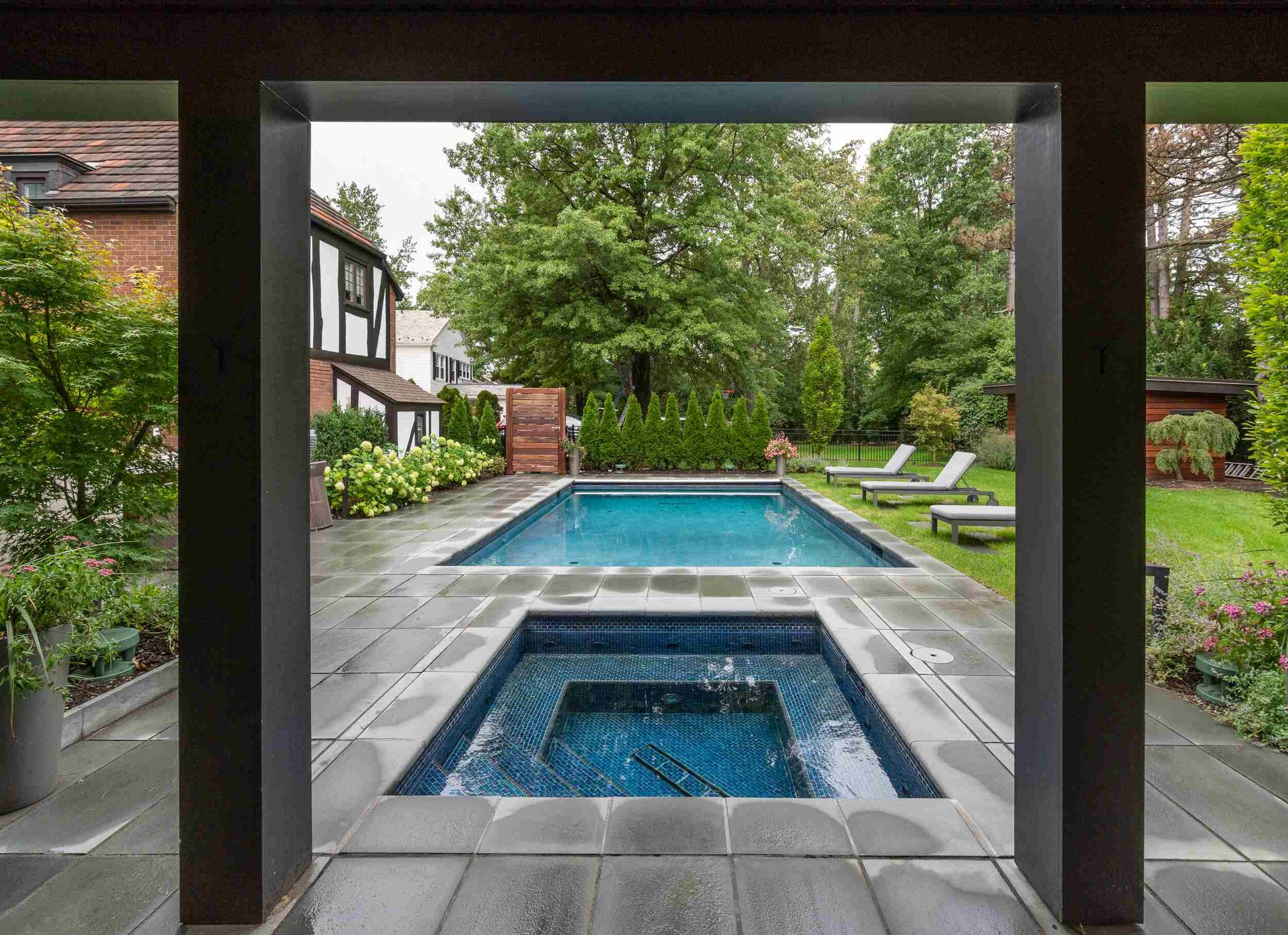 Elegant rectangular swimming pool with a stone deck in a stylish backyard retreat in Novelty, OH