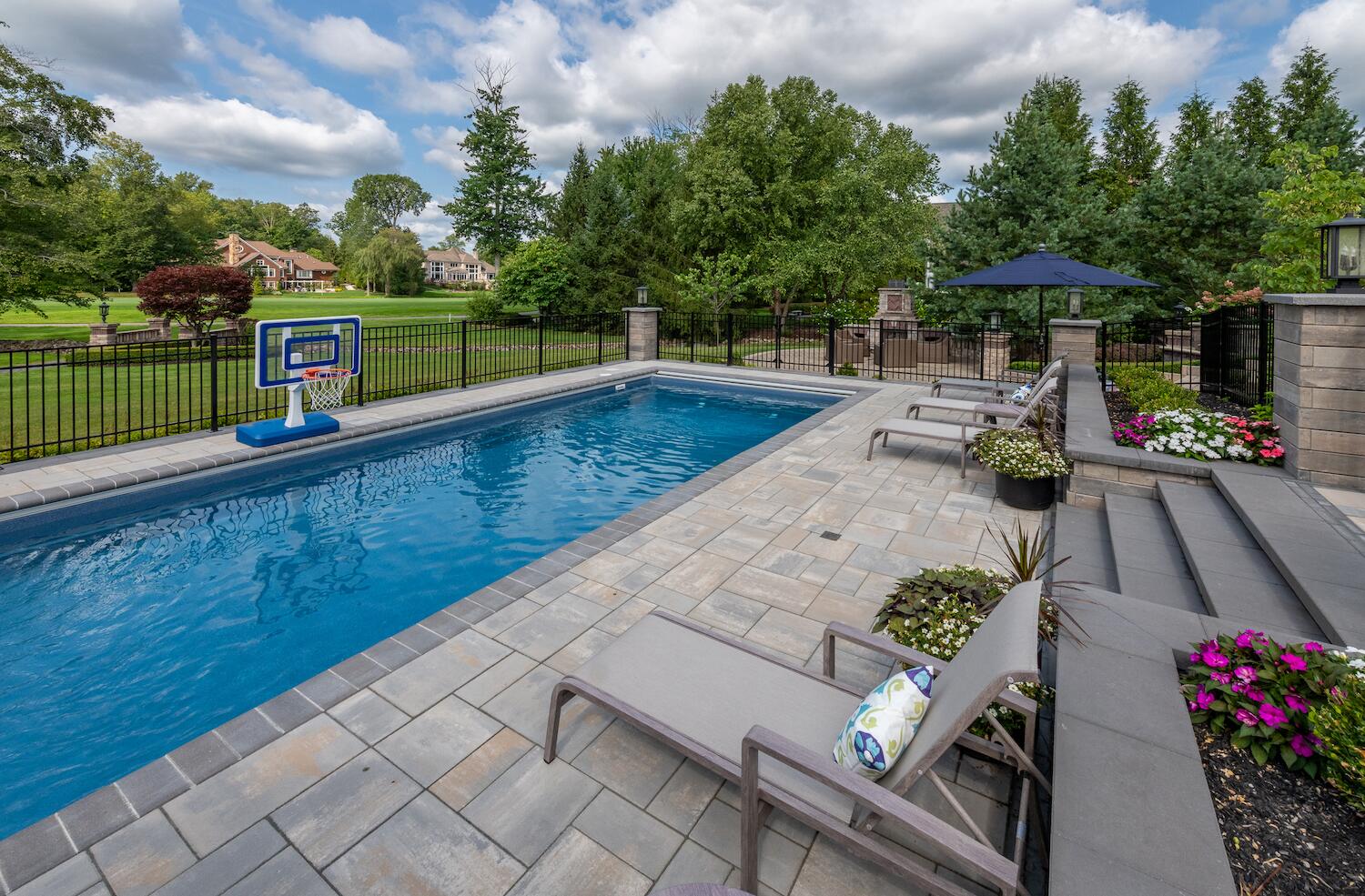 Expansive pool deck with custom pavers and stylish lounge chairs in Moreland Hills, OH (1)