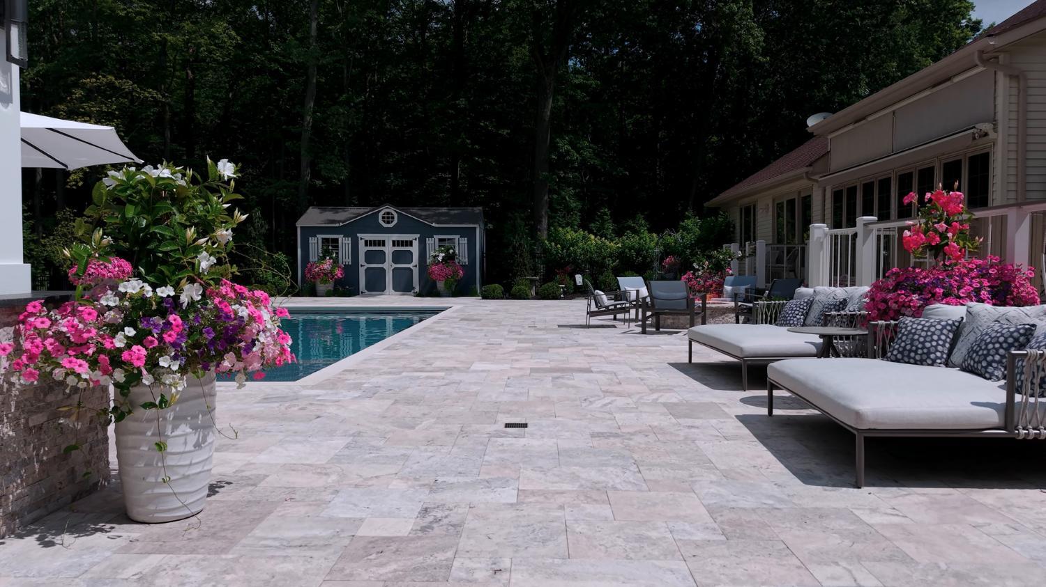 Expansive travertine patio with defined lounging and dining zones in Highland Heights