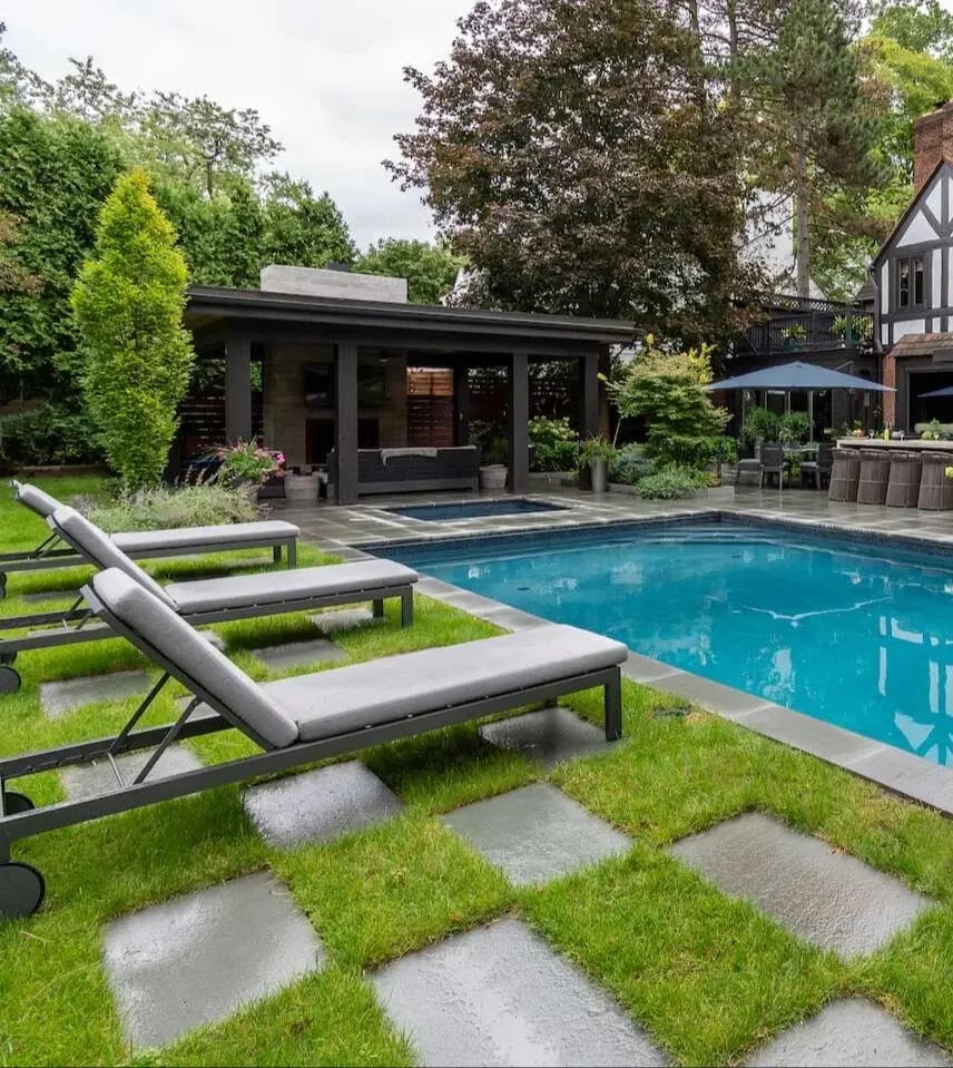 Fully equipped outdoor kitchen with stainless steel appliances and a stone bar in Bainbridge, OH