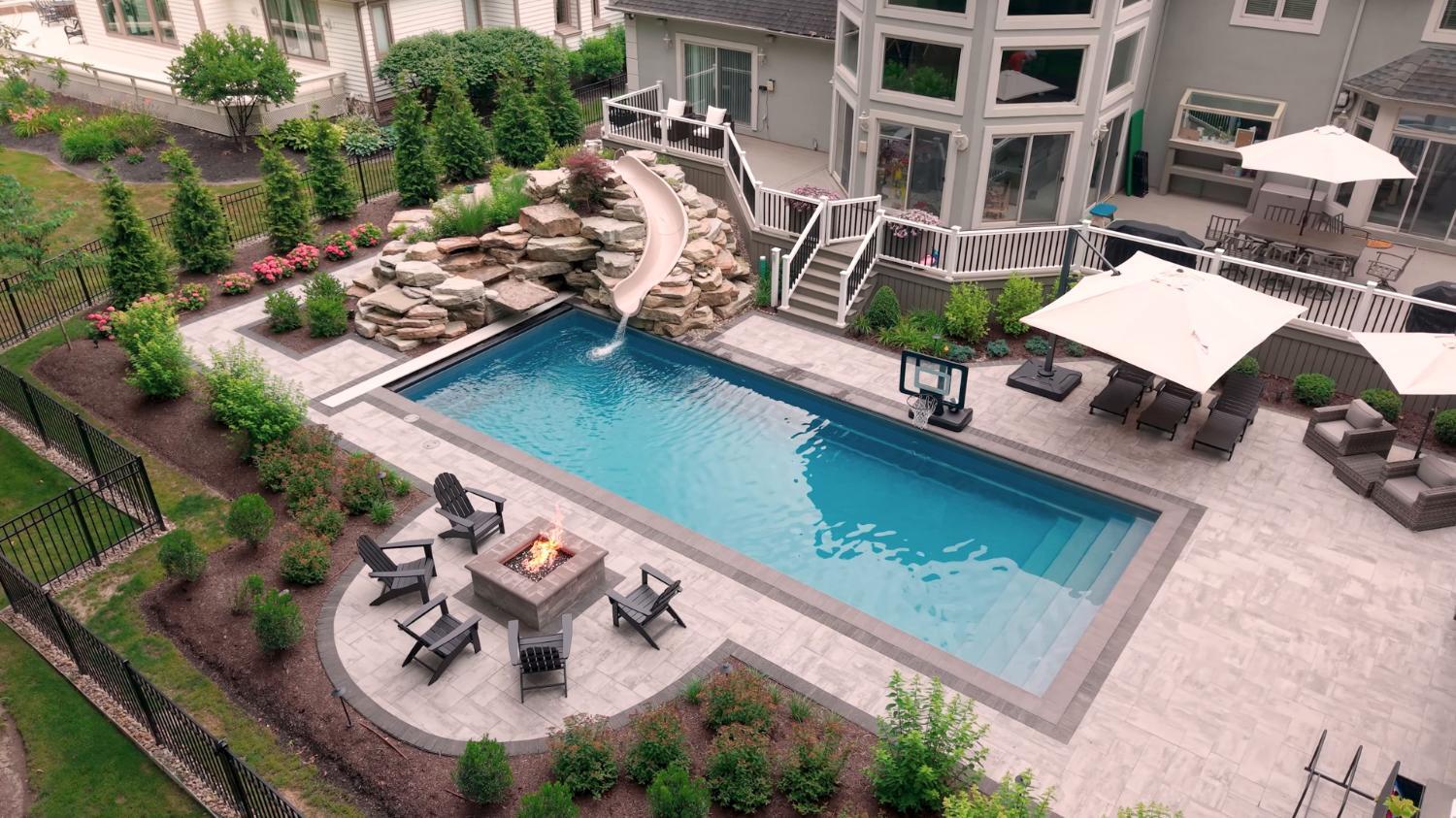 Private backyard pool retreat framed by trees and planting beds in Ohio