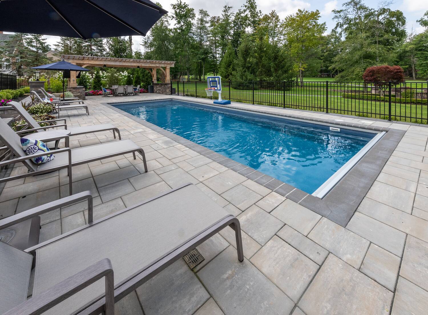 Resort-style pool with spacious lounge seating in a backyard oasis in Novelty, OH