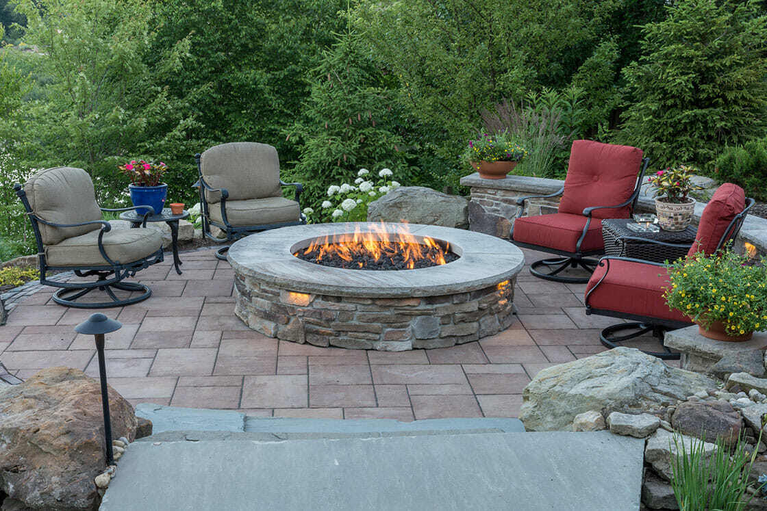 Serene lakeside fire pit surrounded by natural stone in a private backyard in Bainbridge, OH