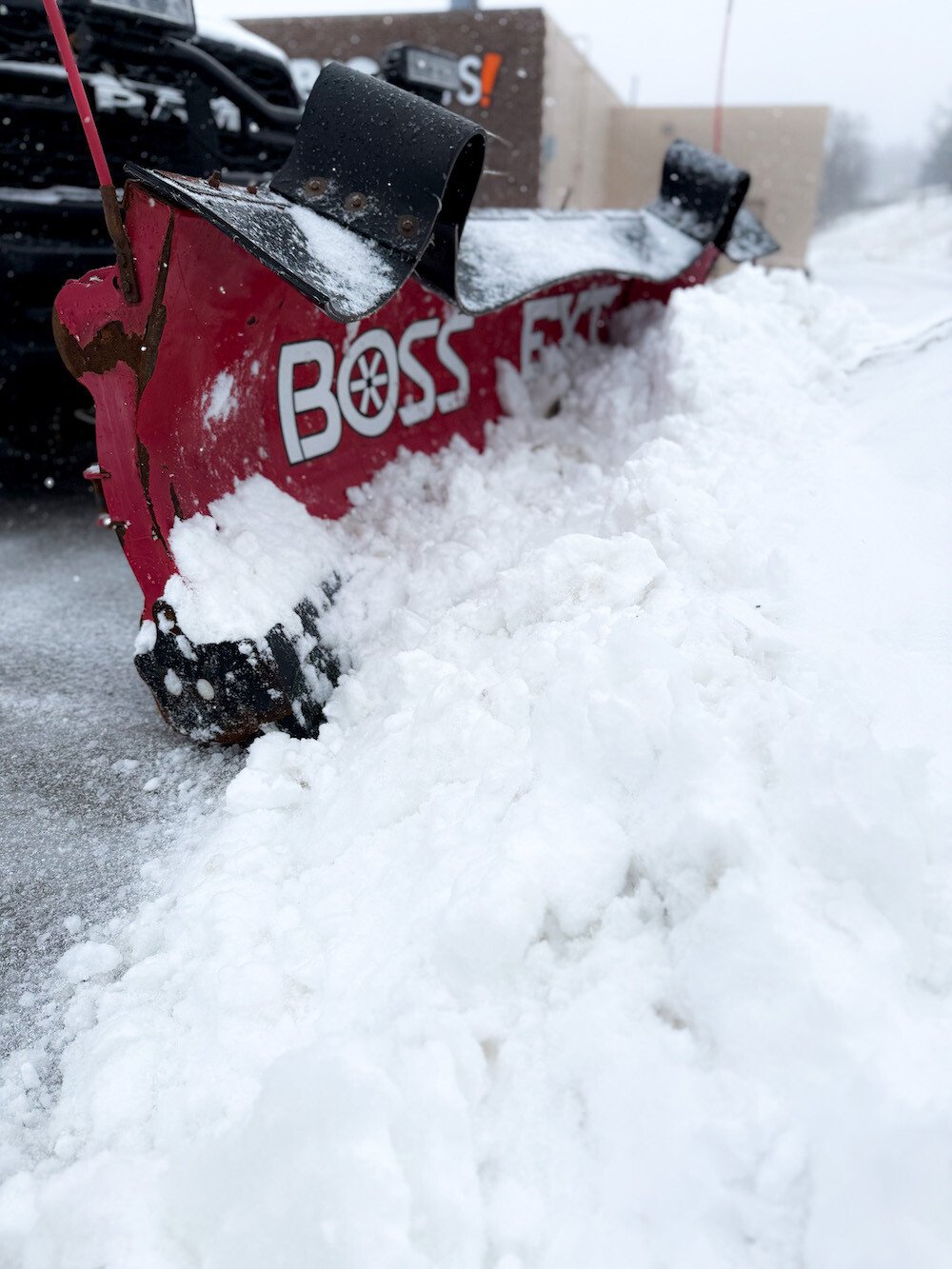 Truck with snow plow attachment servicing a commercial property at sunrise in Aurora, OH-1